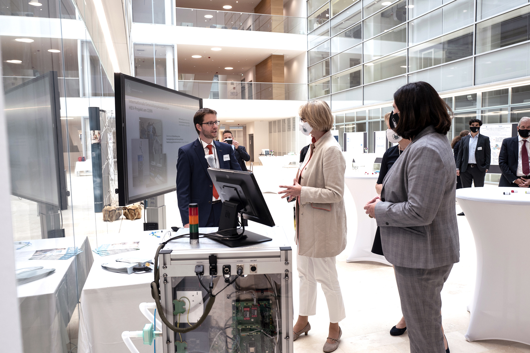 Philipp Rostalski in the foyer of the new research building operating and explaining the HEV unit to the minister and other honorable members of the state and federal parliament.